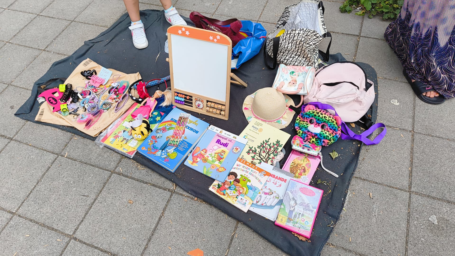 Ausgelegte Spielsachen und Kuscheltiere beim Kinderflohmarkt der Grundschule Kunterbunt