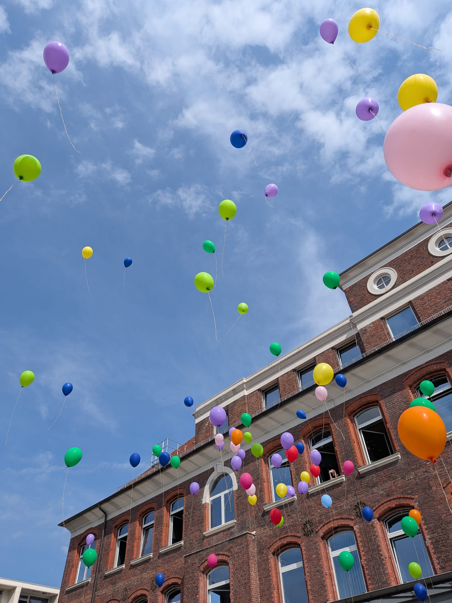 Bunte Ballons steigen bei der Verabschiedung der vierten Klassen in den Himmel.